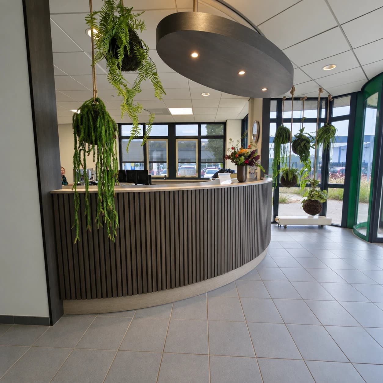 Gebogen kantoorbalie met verticale lamellen en verlichte luifel in Hem